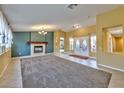 Inviting living room with a decorative fireplace and large windows, tiled floor and neutral color palette at 8212 Cabin Springs Ave, Las Vegas, NV 89131