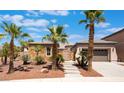 Inviting single-story home with mature palm trees, desert landscaping, and a stone-accented facade at 8536 Grand Palms Cir, Las Vegas, NV 89131