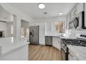 Well lit kitchen featuring stainless steel appliances, white cabinets, and wood style flooring at 8904 Meisenheimer Ave, Las Vegas, NV 89143