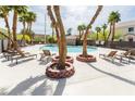 Community pool area surrounded by palm trees and lounge chairs, perfect for relaxation at 10010 Aspen Rose St # 102, Las Vegas, NV 89183