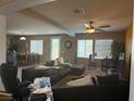 Spacious living room with ceiling fan, neutral paint, and windows overlooking the back yard at 109 Delighted Ave, North Las Vegas, NV 89031