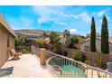 Inviting backyard pool featuring lush landscaping, a small rock waterfall, and great mountain views at 11285 Fiesole St, Las Vegas, NV 89141