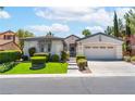 Attractive single-story home featuring a gated entrance, landscaped yard, and a two-car garage at 11405 Perugino Dr, Las Vegas, NV 89138