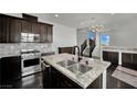 Modern kitchen with stainless steel appliances and a granite countertop island at 1185 Via Dimartini, Henderson, NV 89052