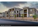 Modern townhome exterior featuring multiple balconies and well manicured landscaping with a stone facade on the entryway at 145 Harmonica Ave # Lot 23, Henderson, NV 89015