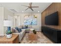 Cozy living room with a plush sectional sofa, modern decor, a ceiling fan, and a decorative wooden accent wall at 145 Harmonica Ave # Lot 23, Henderson, NV 89015