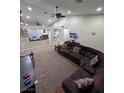 A well-lit living room featuring neutral walls, ceiling fan, and carpeted floors at 1619 Tangerine Rose Dr, Las Vegas, NV 89142