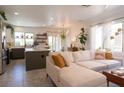 Spacious living room with a comfortable white couch, stylish decor, and an open layout to the kitchen at 2021 Pelican Sky Beach Ave, North Las Vegas, NV 89081