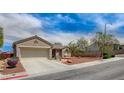 Tan single-story home with desert landscaping, a two-car garage, and a wide driveway at 2804 Sapphire Desert Dr, Henderson, NV 89052
