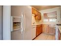 Traditional kitchen featuring wood cabinetry and a refrigerator with water dispenser at 305 Crosswind Way, Las Vegas, NV 89145