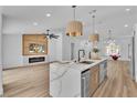 Bright, open kitchen with a large island featuring a breakfast bar and a cozy fireplace in the adjacent living area at 3109 Siena Cir, Las Vegas, NV 89128