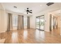 Spacious living room with wood floors, large windows, and a sliding door to the backyard at 3805 Specula Wing Dr, North Las Vegas, NV 89084