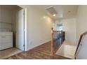 Upstairs hallway featuring wood floors, laundry area, decorative railings, and an open view at 386 Botanic Gardens Dr, Las Vegas, NV 89148