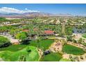 Scenic aerial view of the community with lush green landscaping, ponds, and mountain backdrop at 4208 Agosta Luna Pl, Las Vegas, NV 89135