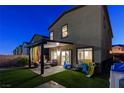 Home's backyard features a covered patio, turf, and lawn for relaxation and playing at 5236 Sunstone Mesa Dr, Las Vegas, NV 89166