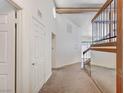 Bright entryway featuring carpet flooring, a high ceiling and access to the staircase at 532 Greenbriar Pl, Boulder City, NV 89005