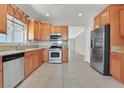 Traditional kitchen with granite countertops, stainless steel appliances, wood cabinets and tile flooring at 6039 Tokara Ave, Las Vegas, NV 89122