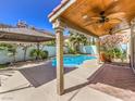 Inviting covered patio with ceiling fans overlooking a sparkling pool and beautifully landscaped backyard at 6779 Goose Watch Ct, Las Vegas, NV 89139