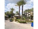 Community gate with palm trees and a small guard station offering secure entry to the neighborhood at 9125 Las Manaitas Ave # 302, Las Vegas, NV 89144