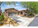 Charming single-story home featuring a well-maintained lawn, mature trees, and an attached two-car garage at 9362 Wilderness Glen Ave, Las Vegas, NV 89178