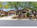 Charming single-story home featuring a well-maintained lawn, mature trees, and an attached two-car garage at 9362 Wilderness Glen Ave, Las Vegas, NV 89178