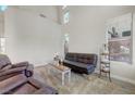 Bright living room with high ceilings, large windows, and comfortable seating area with a plush rug at 9704 Royal Lamb Dr, Las Vegas, NV 89145