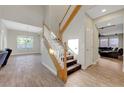 Elegant staircase with wood treads and white risers, complemented by wood-look tile flooring at 9704 Royal Lamb Dr, Las Vegas, NV 89145