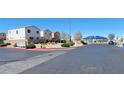 View of a suburban neighborhood featuring landscaping, mailboxes, and a blue shaded structure at 10230 Viterbo St, Las Vegas, NV 89183