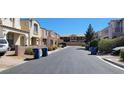 A quiet residential street lined with townhomes and blue recycling bins at 10230 Viterbo St, Las Vegas, NV 89183