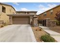 Stylish two-story home features a two-car garage, desert landscaping, and decorative stone accents on the facade at 10440 Bay Ginger Ln, Las Vegas, NV 89135