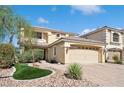 Two-story home with a large front yard, desert landscaping, and an attached two-car garage at 10948 Carberry Hill St, Las Vegas, NV 89141