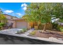 Charming two-story home features a well-maintained front yard, mature tree, and attached two-car garage at 11340 Espadrille Ct, Las Vegas, NV 89138