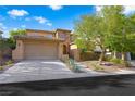 Charming two-story home features a well-maintained front yard, mature tree, and attached two-car garage at 11340 Espadrille Ct, Las Vegas, NV 89138