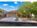 Charming two-story home features a well-maintained front yard, mature tree, and attached two-car garage at 11340 Espadrille Ct, Las Vegas, NV 89138