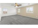 Spacious bedroom with neutral carpet, ceiling fan, and ample natural light from the shuttered windows at 11755 Garland Grove Ln, Las Vegas, NV 89183