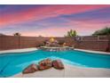 The private backyard pool includes a rock waterfall feature, surrounded by a secure brick fence at 1200 Dream Bridge Dr, Las Vegas, NV 89144