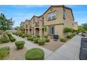 Exterior view of lovely townhomes featuring tidy landscaping and ample parking perfect for community living at 1200 Paradise Basin Ct, Henderson, NV 89002