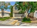 Charming two-story home with a well-maintained lawn and mature trees, enhancing its curb appeal at 1724 Navajo Lake Way, Las Vegas, NV 89128