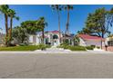 Stunning exterior of a white two-story home with a red tile roof, mature palm trees, and well-manicured landscaping at 2101 Diamond Bar Dr, Las Vegas, NV 89117