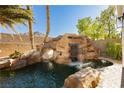 Beautiful backyard pool featuring a rock waterfall and lush greenery at 25 Blue Valley Dr, Henderson, NV 89002