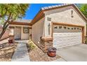 Beautiful home featuring a stone accent wall, a two-car garage and lovely landscaping at 2550 Evening Twilight Ave, Henderson, NV 89044