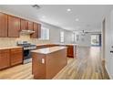 A modern kitchen features stainless steel appliances, wooden cabinets, and an open layout to the living area at 2628 Ferrara St, Henderson, NV 89044