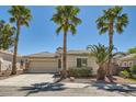 Inviting single-story home featuring mature palm trees and a well-maintained front yard at 2668 Ivoryhill St, Las Vegas, NV 89135