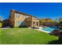 Expansive backyard featuring a manicured lawn, covered patio, and pool at 29 Blue Valley Dr, Henderson, NV 89002