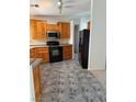 Well-lit kitchen with knotty pine cabinetry, granite countertops, and a black appliance package at 311 Glenoaks St, Pahrump, NV 89048