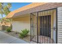 Front entrance featuring brick accents, secure gate, and well-maintained landscaping at 3310 Heritage Pl, Las Vegas, NV 89121