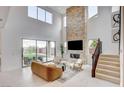 This modern living room boasts a stone fireplace, high ceilings, and access to the backyard at 350 Gandara St, Las Vegas, NV 89138