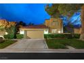 Charming two-story home with a well-maintained lawn, driveway, and two-car garage at dusk at 5125 Turnberry Ln, Las Vegas, NV 89113