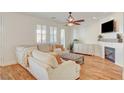 Cozy living room with plush seating, fireplace, and a ceiling fan at 5434 Fawn Chase Way, Las Vegas, NV 89135