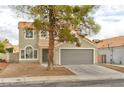 Charming two-story home with desert landscaping, a tile roof and an attached two car garage at 6388 Canyon Dawn Ave, Las Vegas, NV 89108
